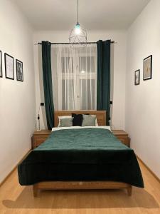 a bedroom with a large bed with a green blanket at Wielopole Classy Rooms in Krakow