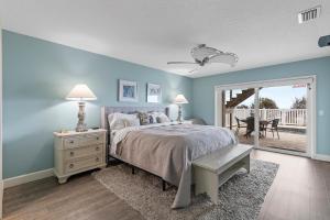 - une chambre avec des murs bleus et un lit avec une fenêtre dans l'établissement Ocean Dream, à New Smyrna Beach