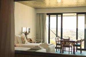 a hotel room with a bed and a table and chairs at Quinta Raposeiros - Ocean View CountryHouse Ericeira in Santo Isidoro