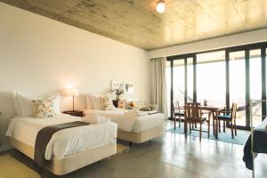 a bedroom with two beds and a table and chairs at Quinta Raposeiros - Ocean View CountryHouse Ericeira in Santo Isidoro +79 photos
