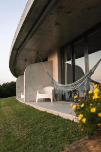 una silla y una hamaca en el porche de una casa en Quinta Raposeiros en Santo Isidoro