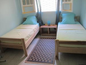 two twin beds in a room with a window at Villa Marie Daniel in Tartane