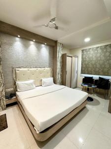 ein Schlafzimmer mit einem großen weißen Bett in einem Zimmer in der Unterkunft Hotel The Heera Divine in Kānpur