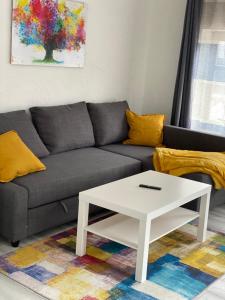 ein Wohnzimmer mit einem grauen Sofa und einem weißen Couchtisch in der Unterkunft Ferienwohnung-Goldener Winkel in Holzminden