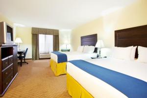 ein Hotelzimmer mit 2 Betten und einem Schreibtisch in der Unterkunft Holiday Inn Express Hotel & Suites Chicago South Lansing, an IHG Hotel in Lansing