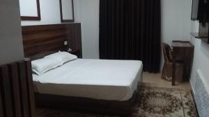 1 dormitorio con 1 cama, 1 mesa y 1 silla en hotel amilcar tataouine en Tataouine