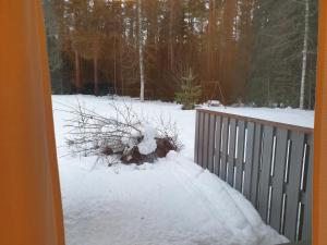a snow covered yard with a bush on a porch at Saunallinen rivitalohuoneisto B5 59m2 in Säviä