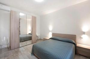 una camera con un letto e un grande specchio di Casavienna app A2 a Varazze