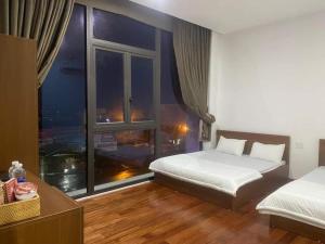 1 dormitorio con 2 camas y ventana grande en NGOC PHUNG HOTEL, en Ban Blech