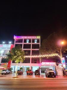 un bâtiment avec des voitures garées dans un parking la nuit dans l'établissement NGOC PHUNG HOTEL, à Ban Blech
