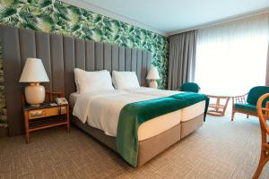 una habitación de hotel con una cama grande y una silla en Eventhotel Pyramide, en Vösendorf