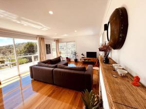 a living room with a couch and a large window at The Coles Bay Shack - Freycinet in Coles Bay