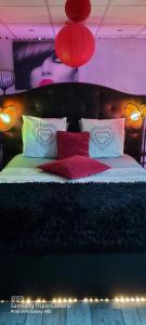 sypialnia z łóżkiem z czerwonymi poduszkami i światłami w obiekcie Péniche Morgane 2 SAS Les Bêtises w mieście Cambrai