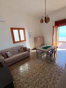 ein Wohnzimmer mit einem Sofa und einem Tisch in der Unterkunft Appartamento vista mare a 10 minuti da Castro Marina in Andrano
