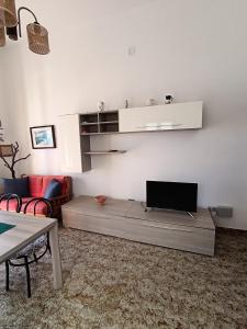 ein Wohnzimmer mit einem Flachbild-TV an der Wand in der Unterkunft Appartamento vista mare a 10 minuti da Castro Marina in Andrano