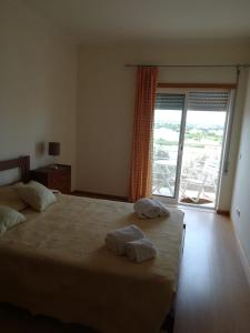 a bedroom with a large bed with two towels on it at Casa dos Avós - Quinas II in Armação de Pêra +17 photos