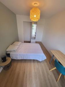 ein Schlafzimmer mit einem Bett und einem Tisch darin in der Unterkunft Logement grand confort in Laval