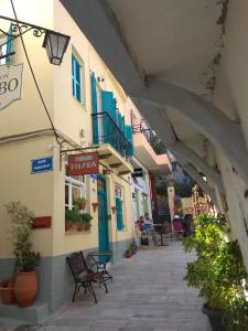 an alley with chairs and tables in a building at Filyra Pension in Nafplio