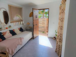 a bedroom with a bed and a door to a patio at La Casa de Piedra a orillas del mar in Vejer de la Frontera