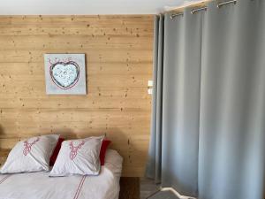 - un lit avec deux oreillers et une photo sur le mur dans l'établissement Chambre de la Tournette, à Saint-Jorioz