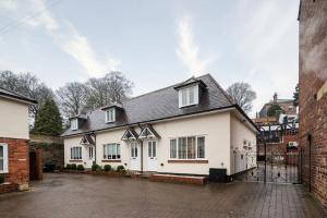 a white house with a black roof at Tranquil Riverfront Oasis at High Bridge Court in Knaresborough