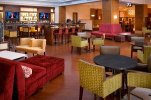 a restaurant with a couch and tables and a bar at Detroit Marriott Troy in Troy