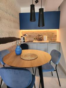 cocina con mesa de madera y sillas azules en Apartament, Wypoczynkowa Rowy, en Rowy