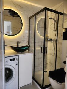 a bathroom with a sink and a washing machine at Apartament, Wypoczynkowa Rowy in Rowy