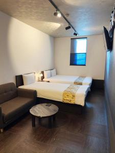 a hotel room with a bed and a couch at Guest House Wagokoro in Tokyo