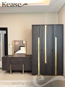 a bedroom with a wooden dresser and a mirror at Kease Al-Mutamarat A-14 Timeless History AG50 in Riyadh