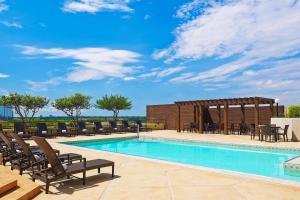 a swimming pool with chairs and a gazebo at The Westin Dallas Park Central in Dallas