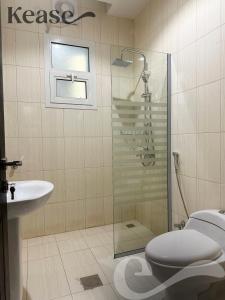 a bathroom with a shower and a toilet and a sink at Kease Al-Mutamarat A-12 Timeless History AZ11 in Riyadh