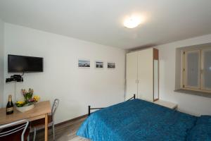 una camera con letto, scrivania e TV di Rossana Apartment Lago Maggiore a Baveno