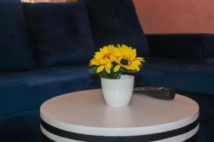 Bungoma的住宿－Trendy Homes - 2 Bedroom，一张花瓶,上面有黄色的花朵,坐在桌子上