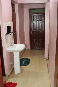 Bungoma的住宿－Trendy Homes - 2 Bedroom，一间带水槽和黑色门的浴室