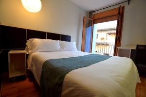 um quarto com uma cama grande e uma janela em Posada Guadalupe em Monroyo