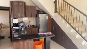 een keuken met een koelkast en een trap bij Madaba hills Villa in Dulaylat al Ḩamāʼidah