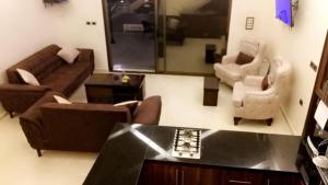 een woonkamer met een bank, stoelen en een tafel bij Madaba hills Villa in Dulaylat al Ḩamāʼidah