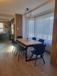 a dining room table and chairs in a room at ZuMiLu House in Zagórz