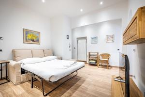 a living room with a bed and a couch at Roommo Via dei Pilastri giada in Florence