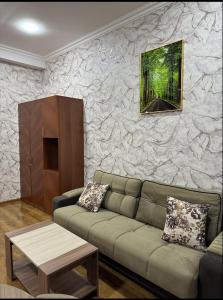 a living room with a couch and a stone wall at Buta Hotel Berde 
