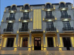 a building with yellow lights on the front of it at Buta Hotel Berde in Bǝrdǝ +12 photos