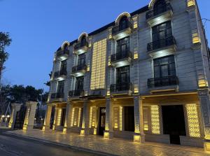 a large building on a city street at night at Buta Hotel Berde in Bǝrdǝ