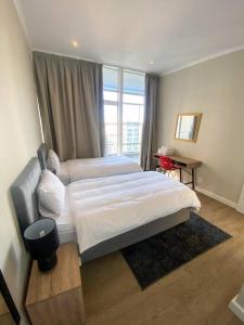 a bedroom with two beds and a large window at Spacious 2-bed unit no-powercuts in Cape Town