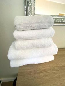 a stack of white towels in front of a mirror at Spacious 2-bed unit no-powercuts in Cape Town