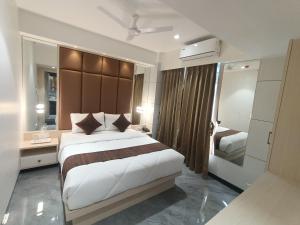 um quarto com uma cama grande e um espelho grande em Hotel Pearl Residency em Thane