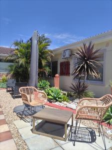 a patio with chairs and a table and an umbrella at @47 Guest House in Gqeberha