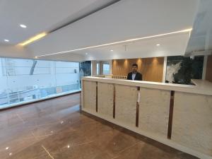 a man sitting at a bar in a building at Hotel Pearl Residency Thane in Thane +82 photos
