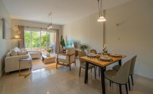 a dining room and living room with a table and chairs at Exquisite 2 Bedroom, Lux Living at Riverside in Nairobi