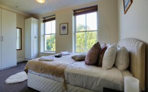 a bedroom with a bed with pillows and windows at Walking distance to Grafton St in Dublin